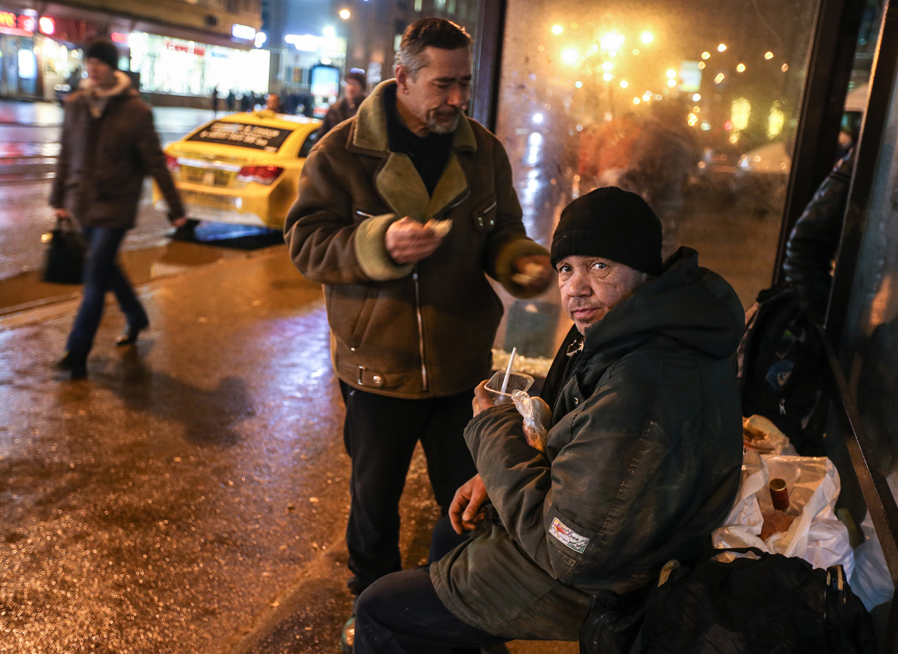Homeless people seen at a bus stop after receiving food handed out by employees of the Spravedlivaya Pomosch ('Just Aid') Fund.
