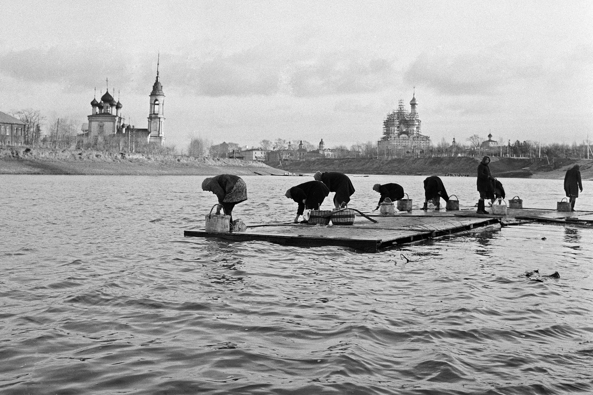 Parfois, on lui demandait de photographier des croquis et des plans. En 1957, Mosstroï lui proposa d’enregistrer le processus de déménagement d’un bâtiment à Moscou. Dans la même année, il fut invité à photographier le Festival de la jeunesse et des étudiants, s’engageant ainsi sur la voie qui, rétrospectivement, lui semblait prédestinée. // Courte pause et nouvelles de l’école, 1965// Photo: Des femmes se lavent dans la rivière.