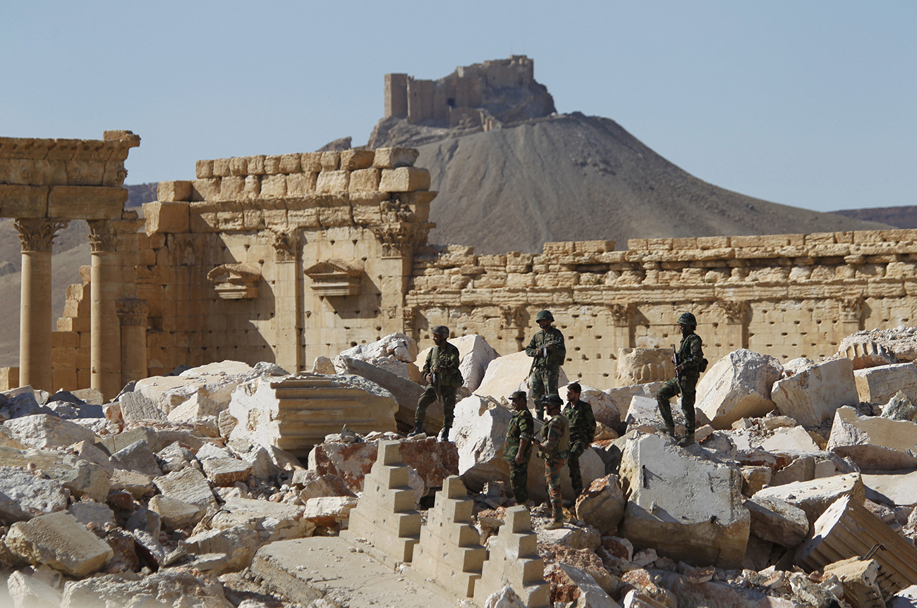 Syrian army soldiers stand on the ruins of the Temple of Bel in the historic city of Palmyra.