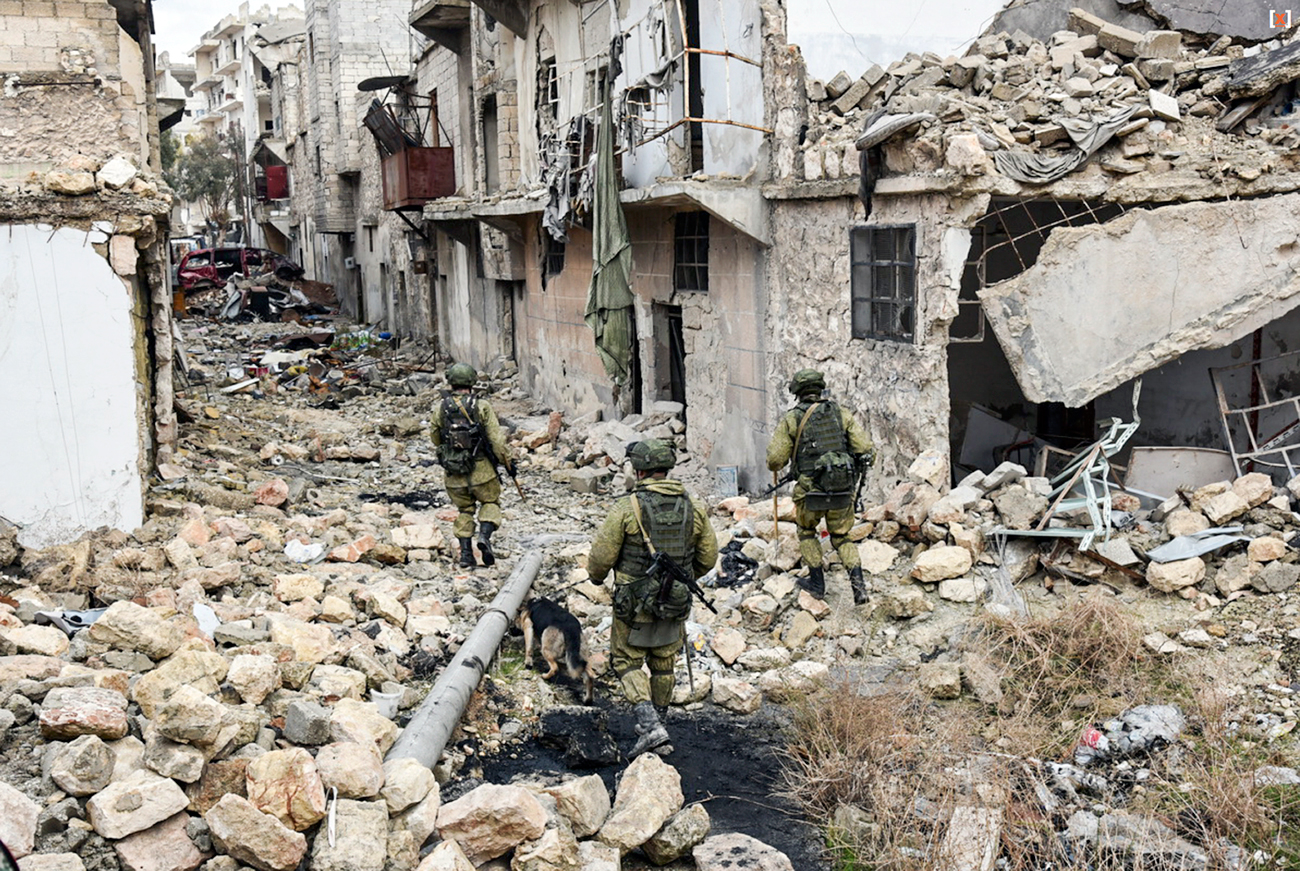 Tiga tentara Rusia menjelajahi puing-puing bangunan di Aleppo, Suriah.