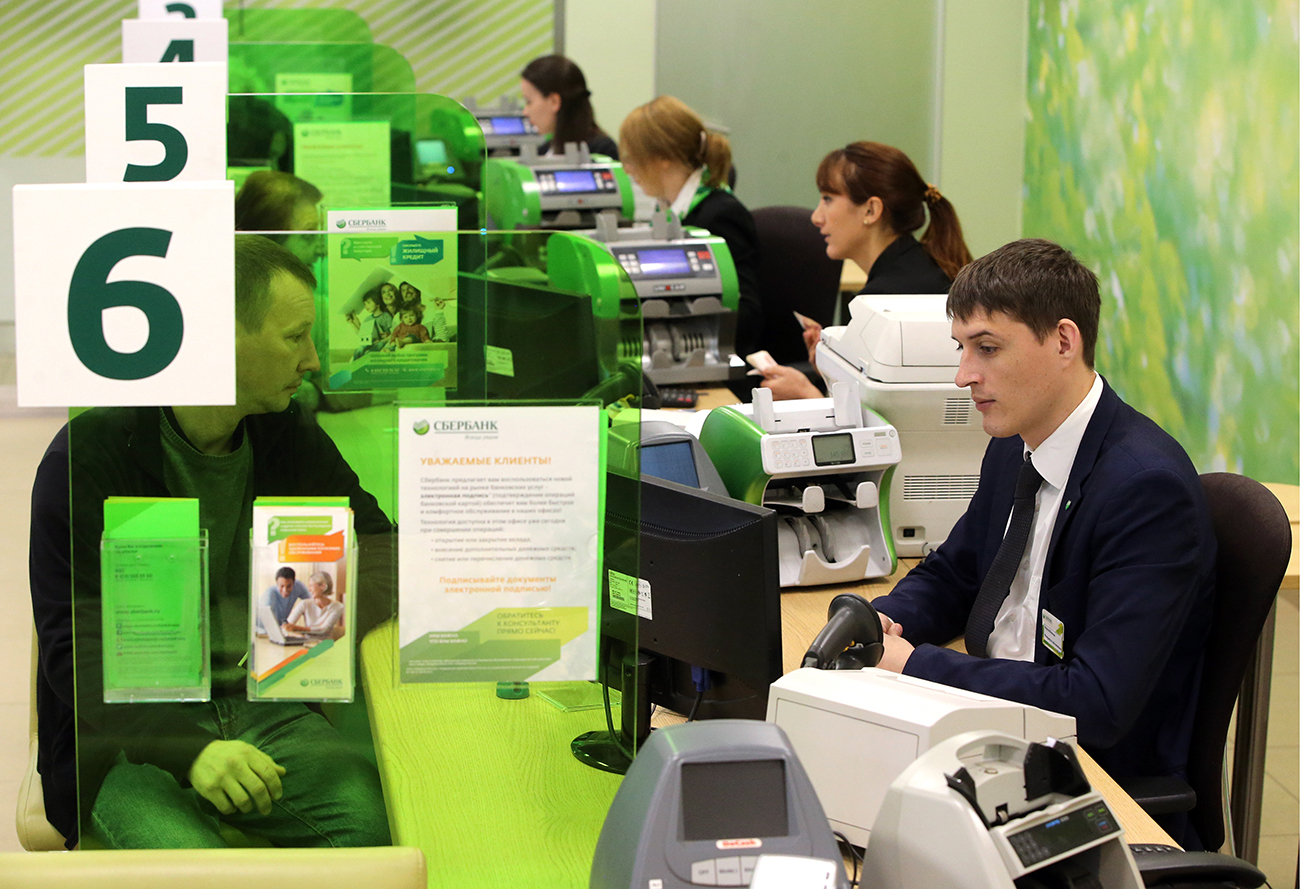Photo: Staff and custmers in a Sberbank branch in St. Petersburg, Russia.