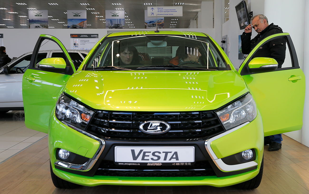 Visitors sit inside a Lada Vesta car, Moscow, March 14, 2016.