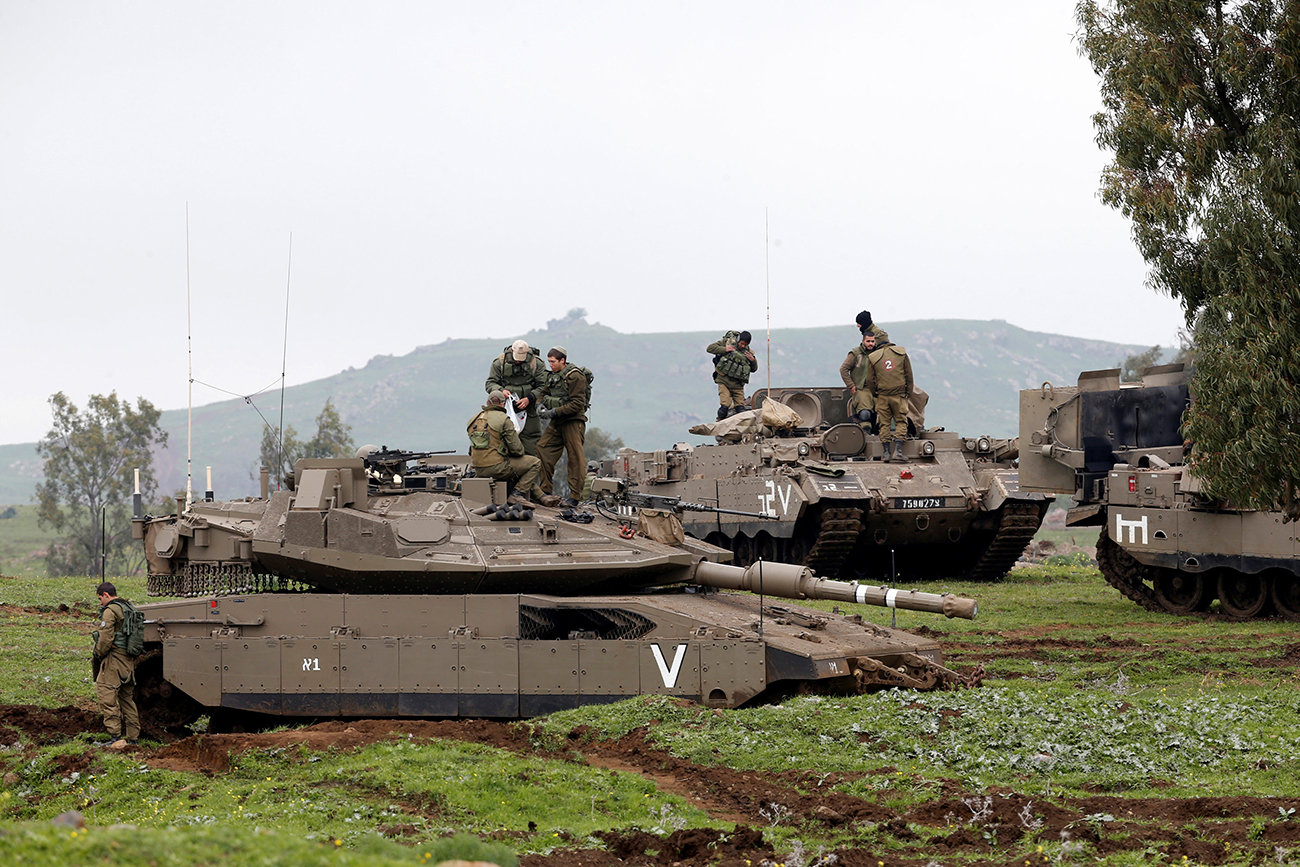 Israeli soldiers stand on top of a tank (front) and an armoured personnel carrier as they take part in an exercise in the Israeli-occupied Golan Heights, near the ceasefire line between Israel and Syria, March 20, 2017. 