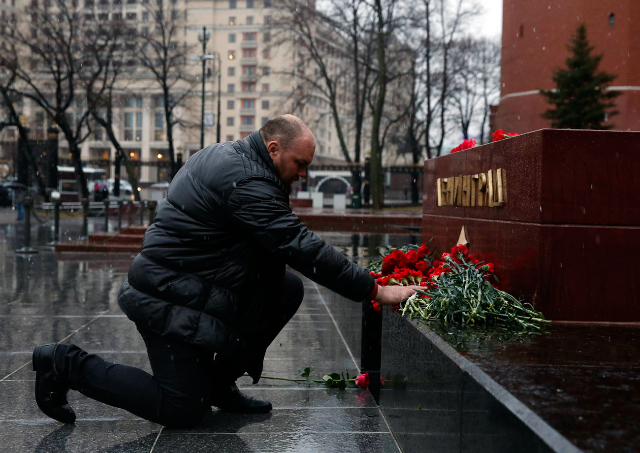 A man lays flowers during a memorial service for victims of a blast in St.Petersburg metro, at a memorial by the Kremlin walls in Moscow, Russia April 3, 2017.