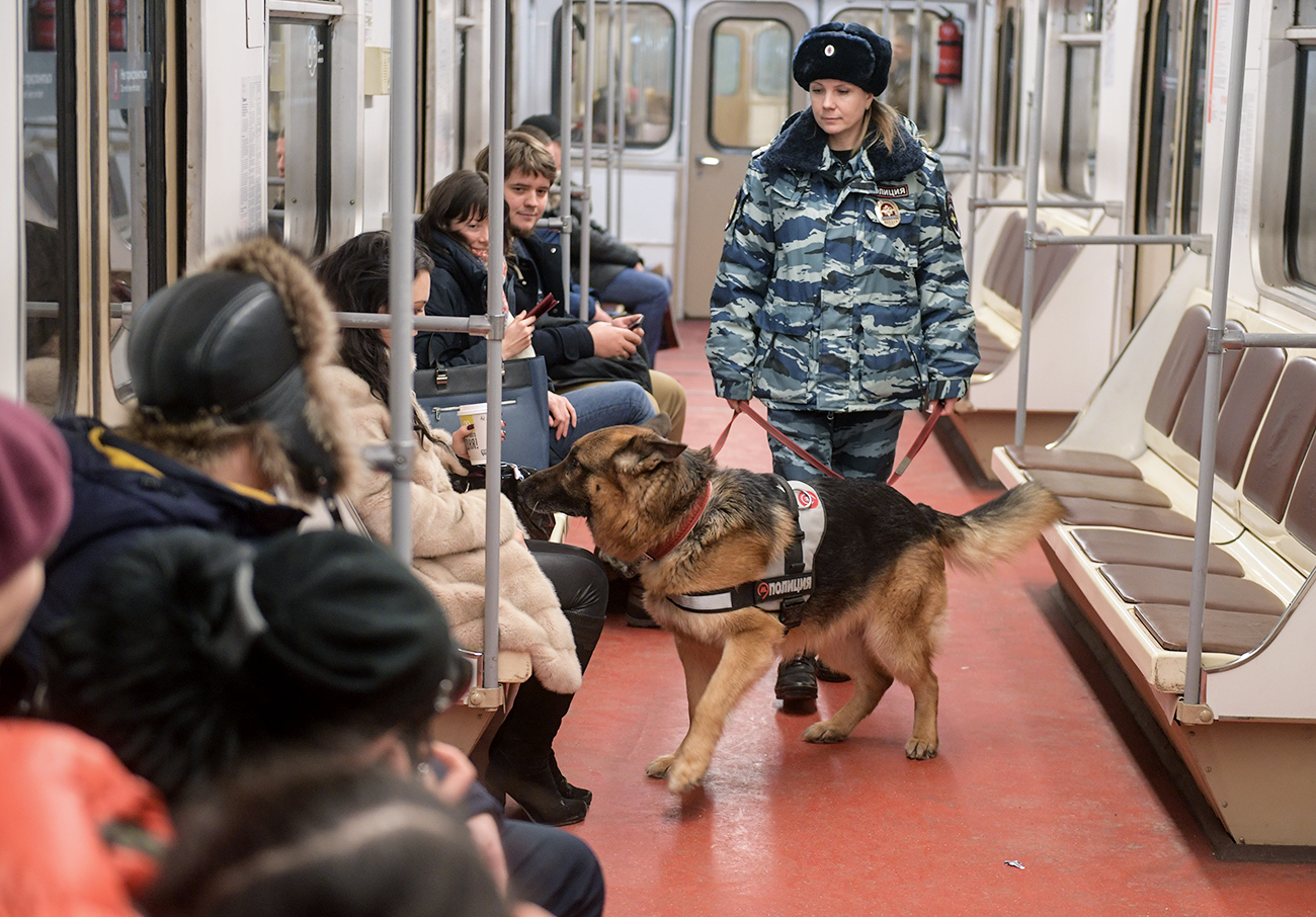 Moscow metro dog service center's employee patrols a Moscow metro station with a dog.