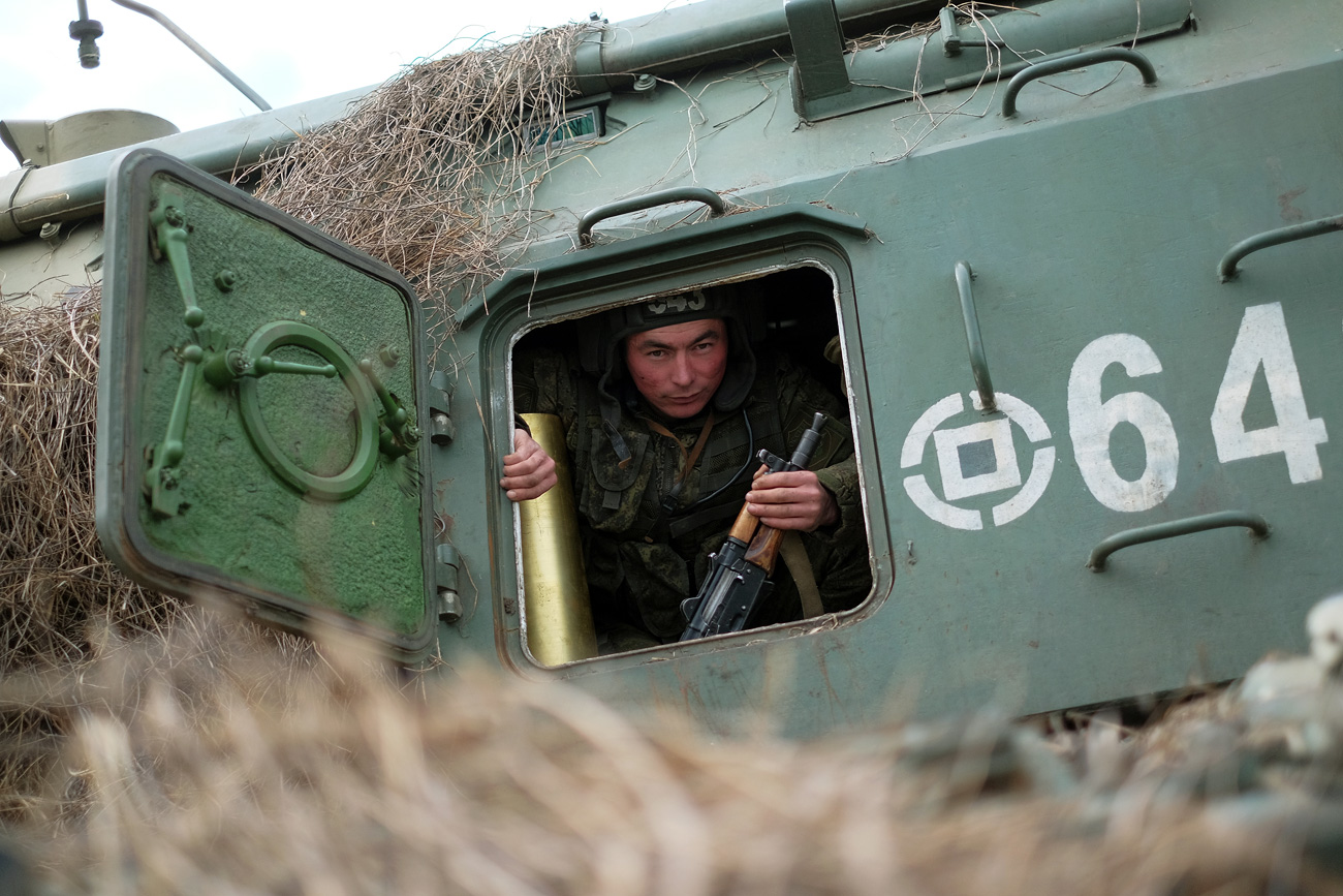 A soldier in the cabin of a Msta-S self-propelled artillery system at Molkino base