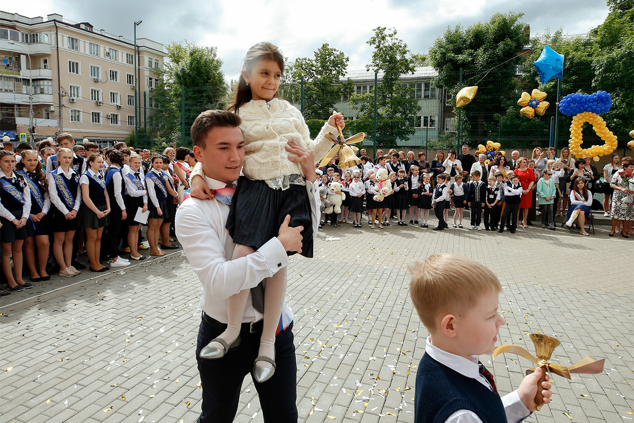 In Russia, this coming-of-age moment is known as the “Last Bell”. It traditionally involves the heftiest final-year student carrying on their shoulders the prettiest first-grader, who rings a large bell.