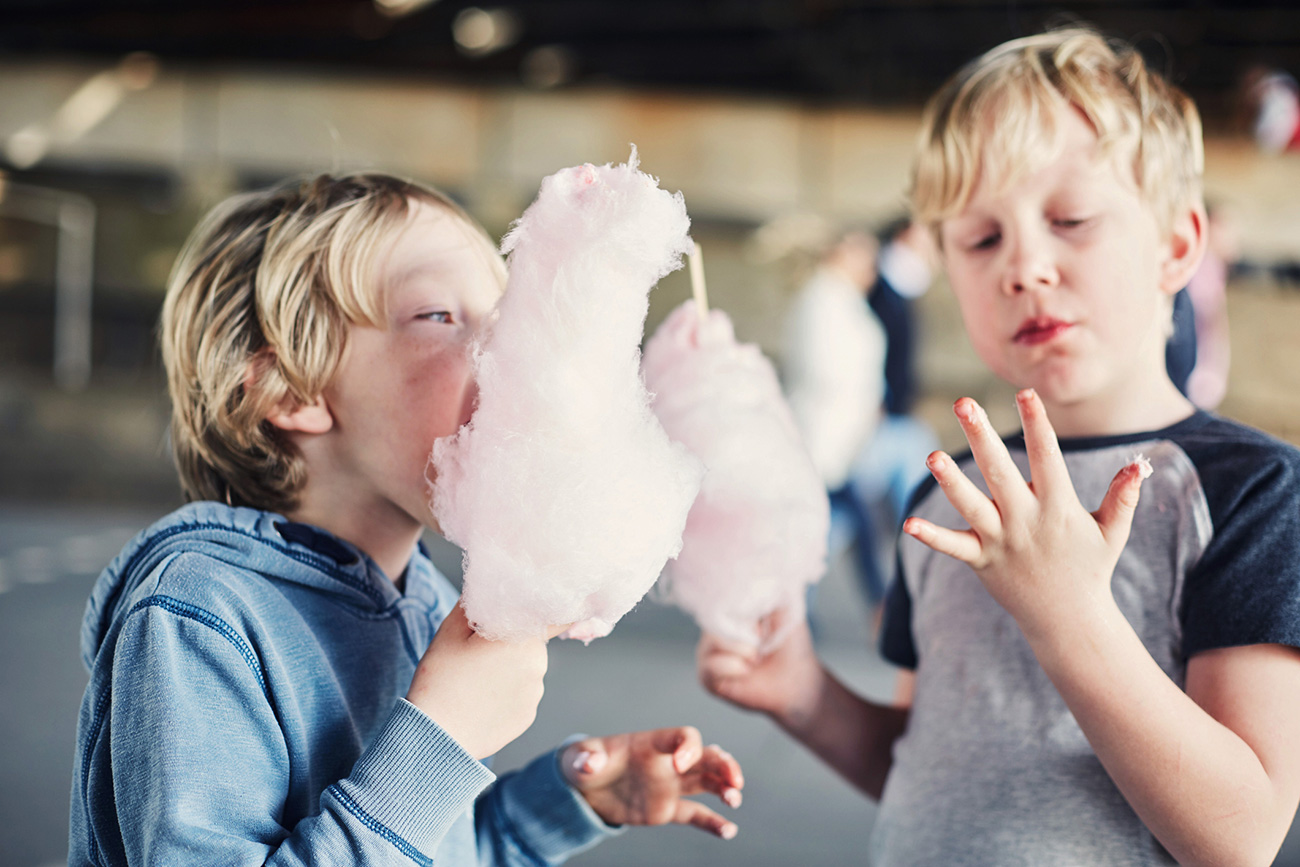 Two little boys eating candy floss