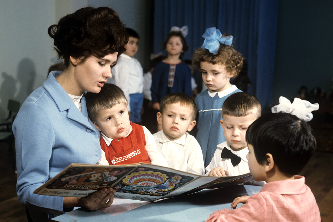 Professora lê para crianças no jardim de infância da fábrica soviética "Kolosok".