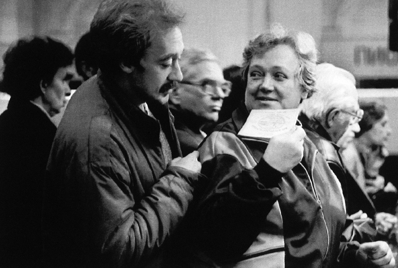 Valentine Shagoleva shows her newly received voucher to her son in St. Petersburg on Oct. 2, 1992 as they line up at a bank counter. The banks began distributing the 10,000 rubles ($40) vouchers to 148 million Russian citizens to buy state-owned enterprises. 