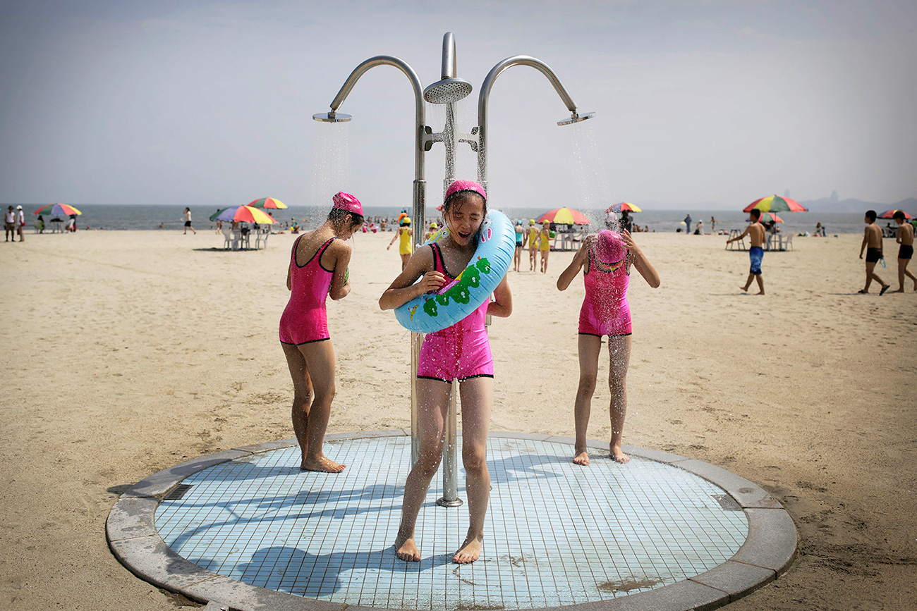 North Korean girls in similar bathing suits stand under a shower at the Songdowon International Children's Camp, Tuesday, July 29, 2014, in Wonsan, North Korea. The camp, which has been operating for nearly 30 years, was originally intended mainly to deepen relations with friendly countries in the Communist or non-aligned world. But officials say they are willing to accept youth from anywhere - even the United States