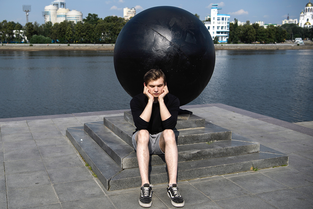 Блогер Руслан Соколовский у одного из гранитных шаров, который закрашен коммунальными службами города в черный цвет, на Октябрьской набережной. Ранее на шаре неизвестными активистами был нарисован знак биткоина. 