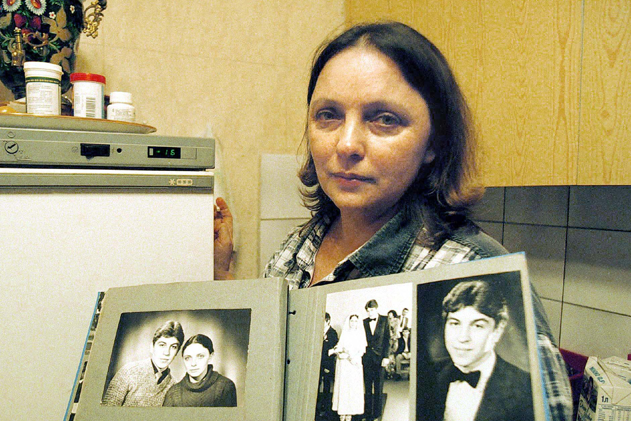 Larisa Savicka, jedina preživjela u sudaru zrakoplova 1981., u rukama drži stare fotografije sebe i muža, Moskva, 2001. / 