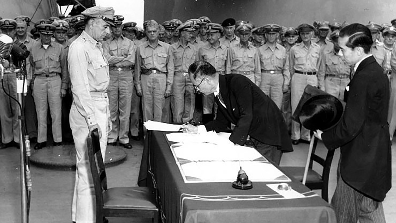 Japanese foreign affairs minister Mamoru Shigemitsu signs the Japanese Instrument of Surrender on board USS Missouri as General Richard K. Sutherland watches, Sept. 2, 1945.