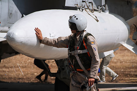 Strike force: A Russian pilot checks the  ordnance before taking off from Hemeimeem air base in Syria.