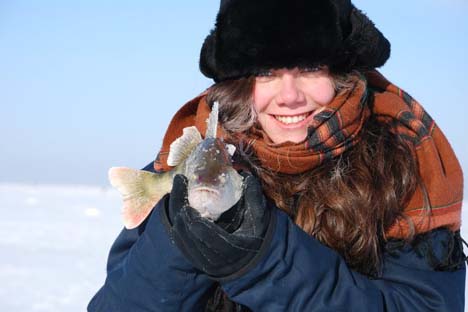 Marina segura um ômul, peixe encontrado apenas nas águas do lago Baikal Foto: arquivo pessoal