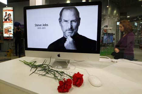 Flores diante de uma tela de computador com o retrato de Steve Jobs em loja da Apple em São Petersburgo Foto: Aleksandr Demianchuk/Reuters/Vostock-Photo