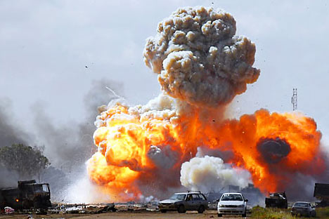 Vehicles belonging to forces loyal to Libyan leader Muammar Gaddafi explode after an air strike by coalition forces, along a road between Benghazi and Ajdabiyah. Source: Reuters / Vostock Photo
