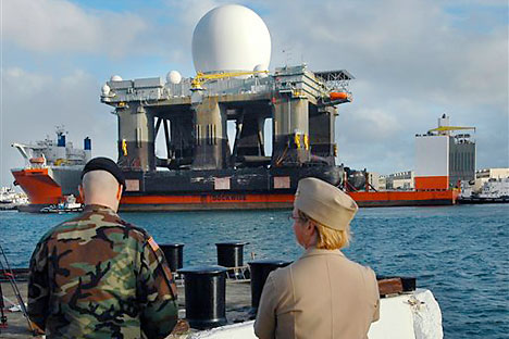 Military personel watch as the Sea-Based X-Band Radar sails into Pearl Harbor, Hawaii, aboard the MV Blue Marlin. The 280-foot tall Sea-Based X-band Radar is so powerful it can identify baseball-sized objects from thousands of miles away. US army was