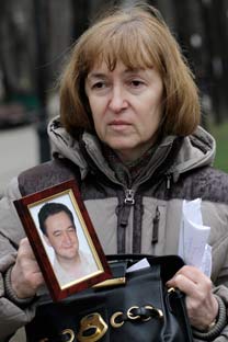 Natalya Magnitskaya holds a portrait of her son, Sergei. Source: AP