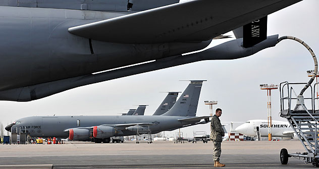 A US soldier stands near a plane bound for Afghanistan, as it fuels up at the Manas Transit Center some 30kms from Bishkek. Source: AFP/East News