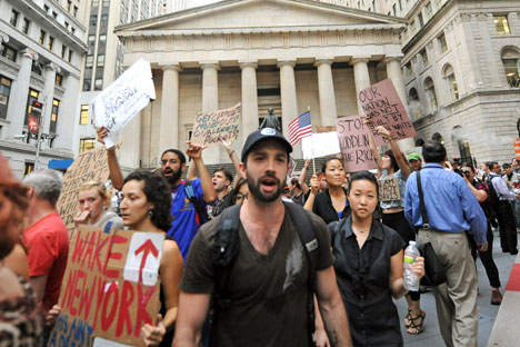 Protestors march past Federal Hall on Wall Street, Monday, Sept. 26, 2011, in New York. The "Occupy Wall Street" protest is in its second week, as demonstrators speak out against corporate greed and social inequality. Source: AP