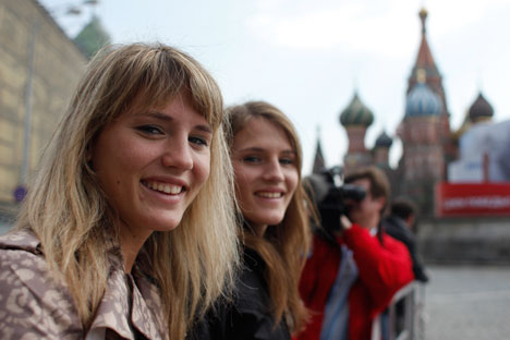 Twin sisters Jennifer, left, and Jessica, pose for a photo in front of St. Basil's Cathedral in the Red Square in Moscow. Photo: AP
