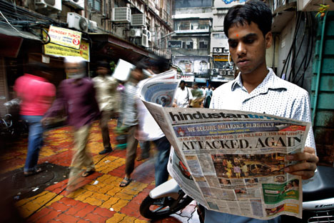 A man reads a newspaper with details of the bomb explosions at Zaveri bazaar area, near one of the bomb explosion sites, in Mumbai, India. Source: AP