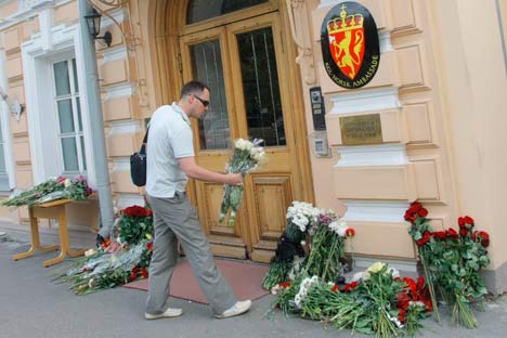 A man lay flowers in front of the Embassy of Norway in Moscow, in memory of the explosion and shooting victims. (AP Photo/Mikhail Metzel)