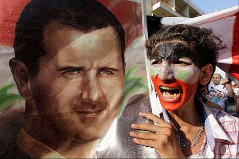 Un manifestante siriano grida slogan e mostra un'immagine del presidente siriano Bashar Assad, durante una manifestazione a favore di Assad di fronte l'Ambasciata di Siria a Beirut (Foto: AP/Bilal Hussein)