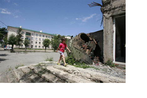 A girl walks past a tank turret, destroyedduring Georgia's war with Russia over SouthOssetia, in Tskhinvali, July 23, 2010  source Vostock photo