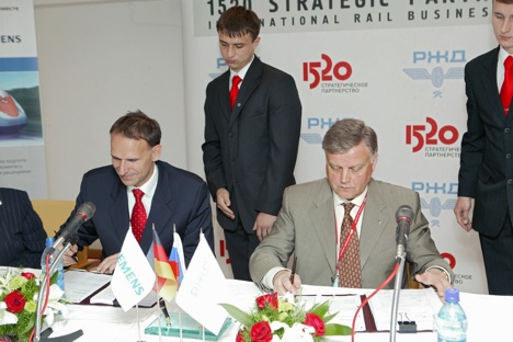 Der eine lächelt, der andere nicht: Siemens-Transportation-Group-Präsident Hans Schabert und Chef der Russischen Eisenbahn Boris Jakunin unterzeichnen Abkommen. Foto: Kommersant
