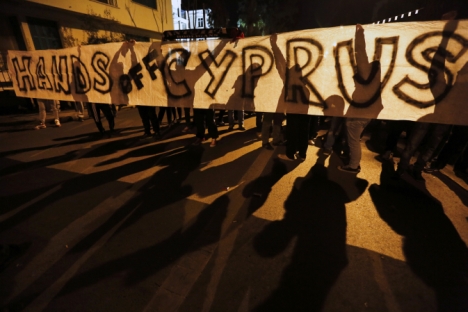 Manifestantes anti-Troika seguram faixa com os dizeres "Tirem as mãos do Chipre" durante protesto na frente do escritório da UE, em Nicósia Foto: Reuters