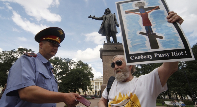 A police officer checks documents of participant in a rally in support of punk group Pussy Riot on Arts Square in St. Petersburg. Source: RIA Novosti / Vadim Zhernov 