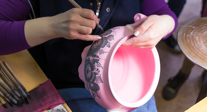 Gzhel artist at work on a vase at a Gzhel facility, manufacturing Russian folk art porcelain. Source: Lori/Legion Media