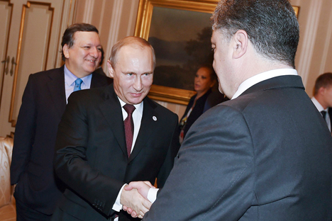 Pútin (à esq.) cumprimenta o presidente ucraniano Petrô Porochenko em reunião realizada no ano passado Foto: Reuters