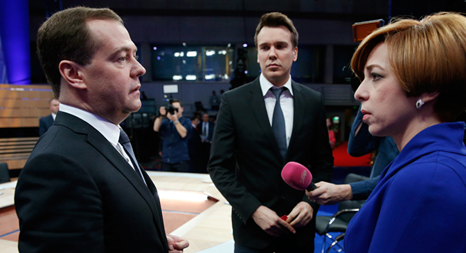 Russia's Prime Minister, Dmitry Medvedev, left, speaks during a live nation-wide TV show at Moscow's Ostankino TV center, Russia, Wednesday, Dec. 10, 2014. Mikhail Zygar of Dozhd, center, and Marianna Maksimovskaya of REN TV listen. Source: AP