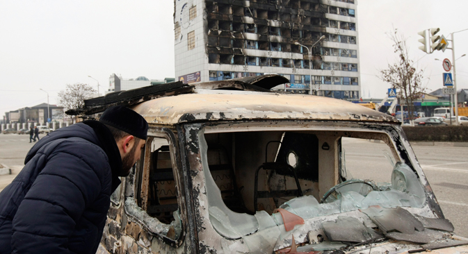 Čovjek zaviruje u spaljeni auto kraj Novinarskog doma, zgrade lokalne novinske agencije u čečenskom glavnom gradu Groznom, 3. prosinca, 2014. Najmanje šest napadača i tri policajca je ubijeno u oružanim bitkama u kojima je izvršen upad u čečenski glavni grad Grozni u utorak, izjavio je lider ove turbulentne južne ruske regije. Izvor: Reuters
