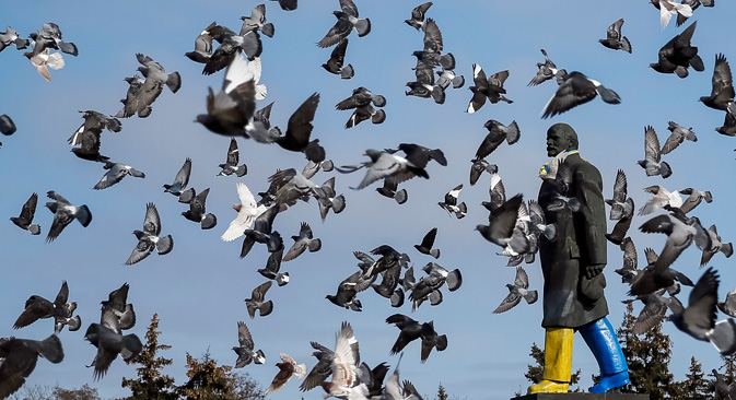 Pigeons fly around a monument of the Soviet state founder Vladimir Lenin painted in the colors of the Ukrainian national flag is seen in Kramatorsk, eastern Ukraine February 11, 2015. Source: Reuters