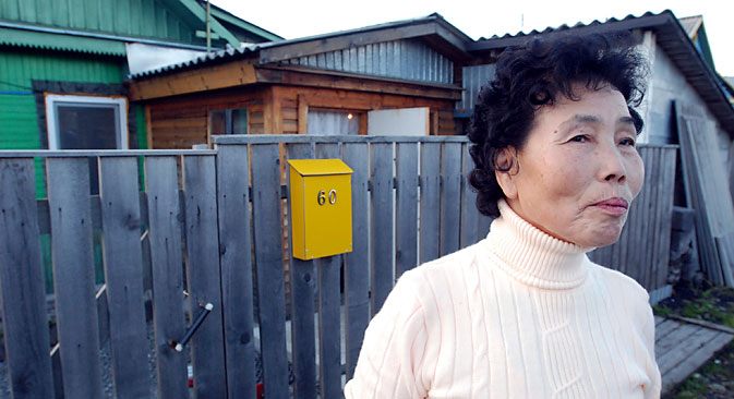  Pak Den Dya, an ethnic Korean living on Russia's Sakhalin Island, poses in front of her home in Yuzhno-Sakhalinsk, Russia. Source: AP Photo/Burt Herman