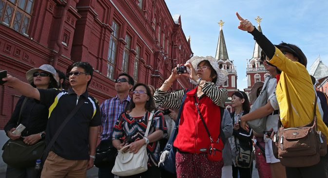 Tourists near the State Historical Museum of Russia in front of the Resurrection Gate, Moscow. Source:  ITAR-TASS/ Artyom Geodakyan