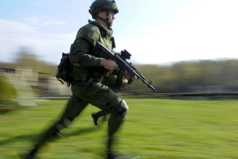 Seorang tentara mengenakan seragam tempur 'Ratnik' dengan menenteng Kalashnikov AK-12 di area tembak.