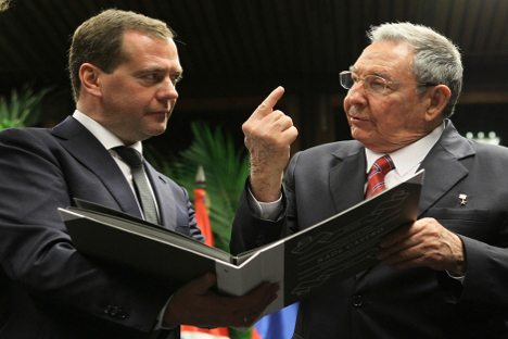 Dmitri Medvédev, primer ministro ruso, sostiene un álbum alte Raúl Castro. Fuente: Reuters.