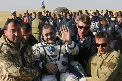El personal de tierra de la Agencia Espacial rusa lleva en brazos a Pável Vinogradov (centro), Alexander Misurkin (detrás a la derecha) y al estadounidense Chris Cassidy (detrás a la izquierda) poco después de aterrizar en la nave Soyuz a unos 146 kilómetros del pueblo de Zhezkazgan, Kazajistán. Fuente: Reuters