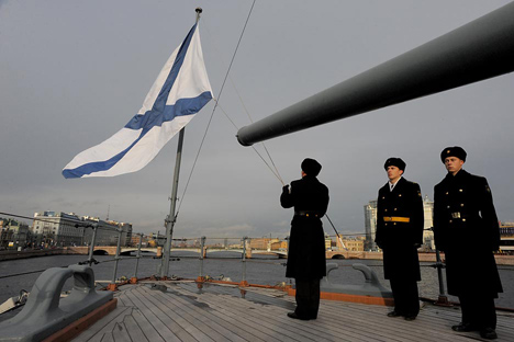 Un miembro de la marina rusa coloca la bandera a media asta en conmemoración del final de la Primera Guerra Mundial en el crucero Aurora, situado en San Petersburgo. Fuente: AFP / East News