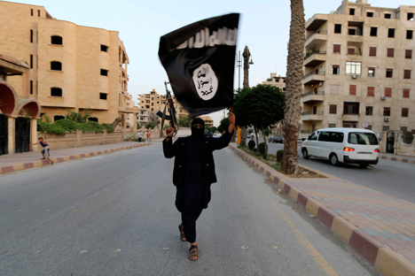 Hombre con bandera del Estado Islámico en Raqqa, Siria. Fuente: Reuters. 