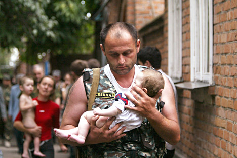 Oficial de policía con un bebé que estaba secuestrado por los terroristas en el ataque a la escuela de Beslán.