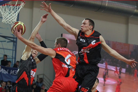 Les joueurs de l’équipe « Vostok » (Est), Stanislav Kraïnov (à gauche) et Denis Krouglov (à droite) et le joueur de l’équipe « Zapad » (Ouest) Evaldas Rastenis (au centre) dans le match des stars de la Ligue étudiante internationale de basket-ball au