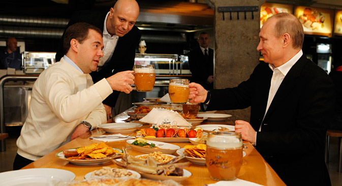 Le premier ministre russe Dmitri Medvedev (à gauche) et le président russe Vladimir Poutine boivent de la bière au bar Jigouli, dans le centre de Moscou. Crédit : Itar-Tass