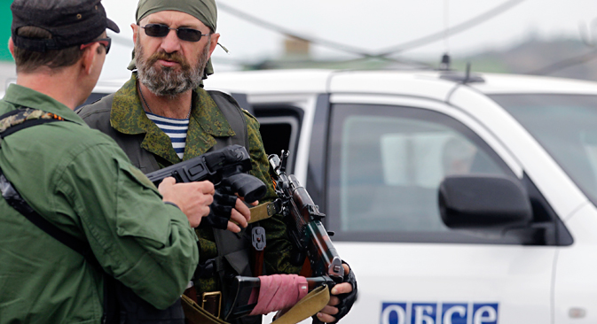 Un insurgé ukrainien près de la voiture de l'OSCE près du village Nijnïaïa Krynka, est de l'Ukraine. Crédit : AP